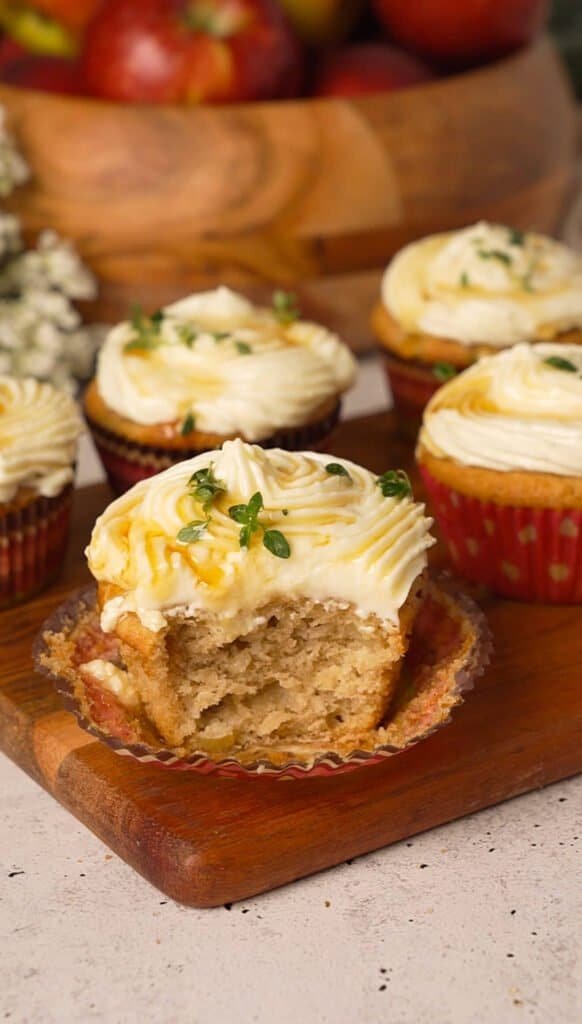 Apple cupcake with a bite taken out, showing the moist spiced crumb