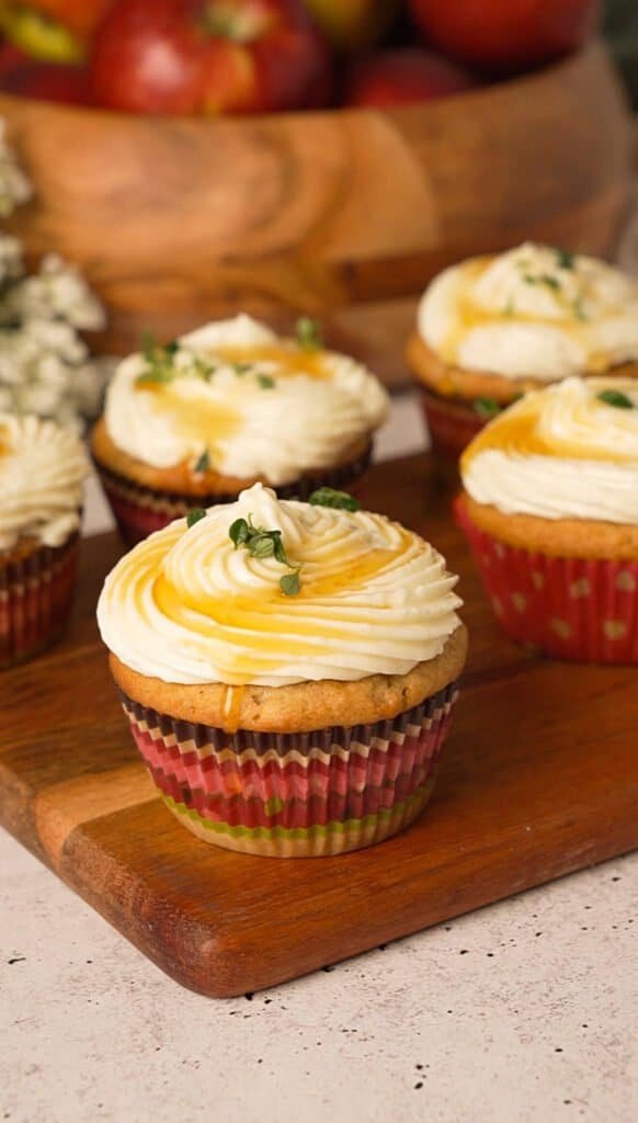 Baked apple cupcakes topped with brie frosting, honey, and fresh thyme