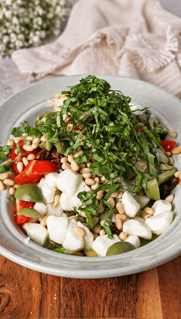 Marinated mozzarella dip finished with fresh basil, toasted pine nuts, cherry tomatoes, and green olives.