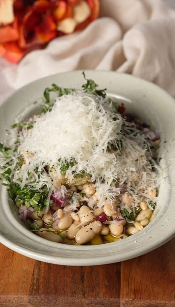 Shredded Parmesan added on top of marinated white bean dip