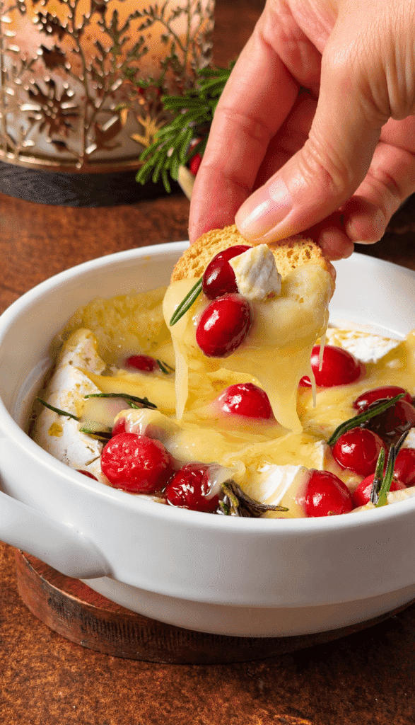 Toast topped with melted Brie, fresh cranberries, rosemary, and honey