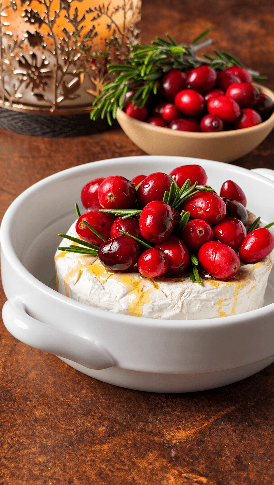 Brie topped with fresh cranberries, rosemary, and honey before baking